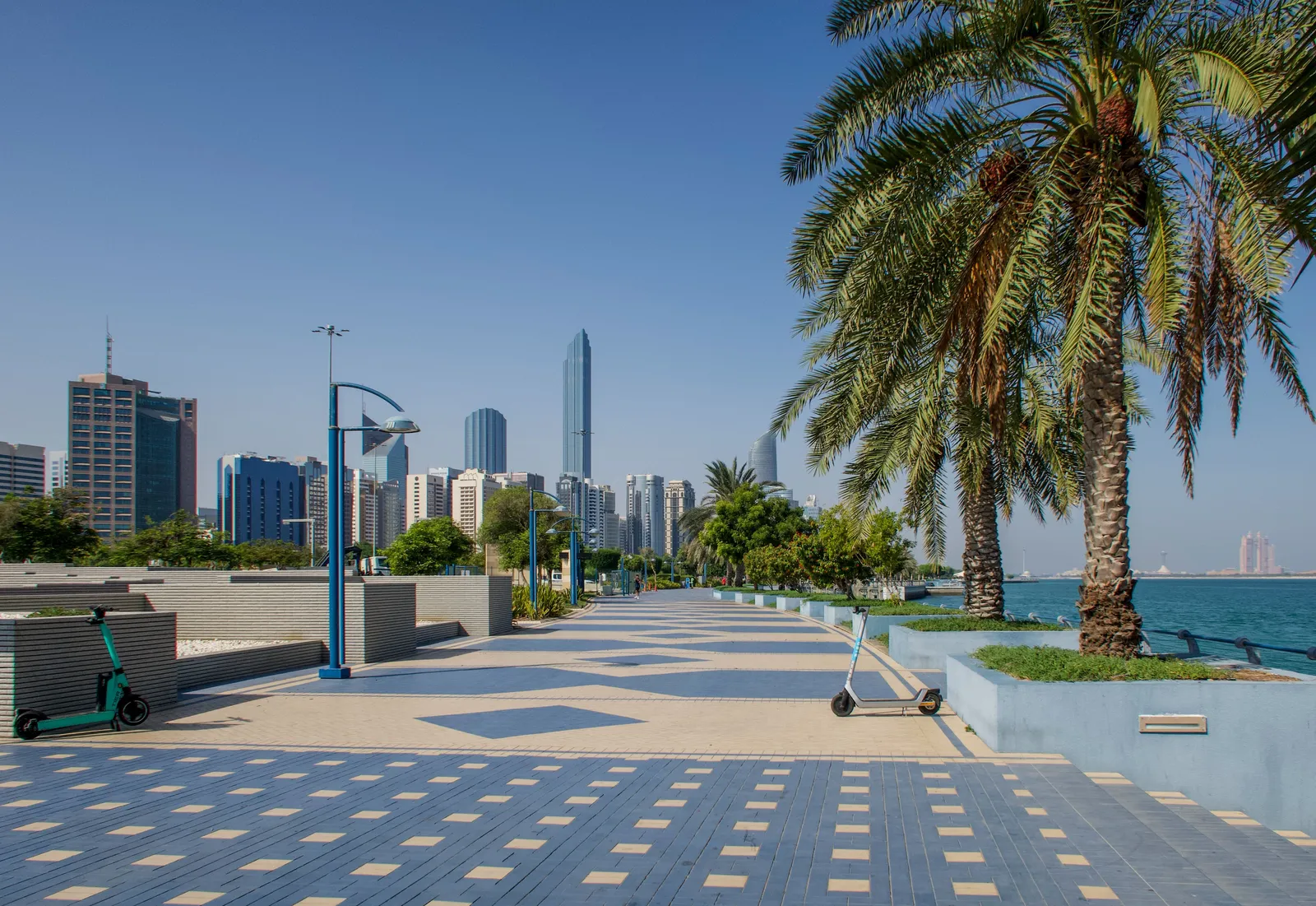 The palm lined Corniche promenade with the Abu Dhabi skyline and the sea