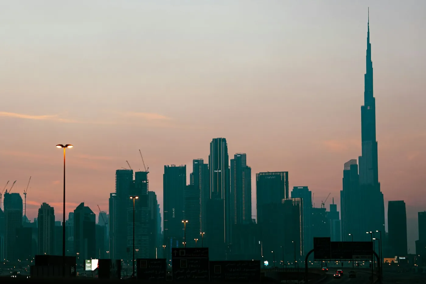 The Dubai skyline at sunset with the Burj Khalifa on the horizon