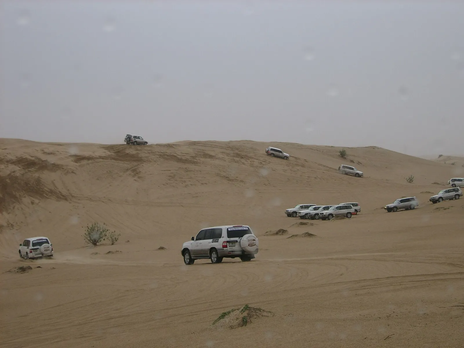 Four wheel drive vehicles driving over sand dunes in the desert near Dubai, United Arab Emirates