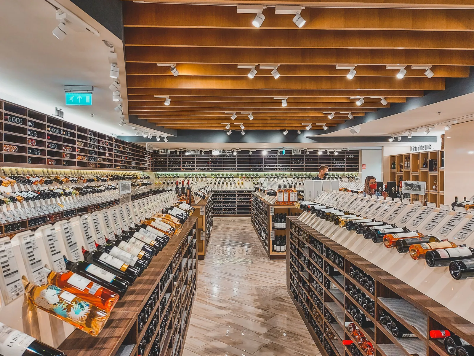 Rows of wine and spirit bottles on the shelves of a modern drinks shop interior
