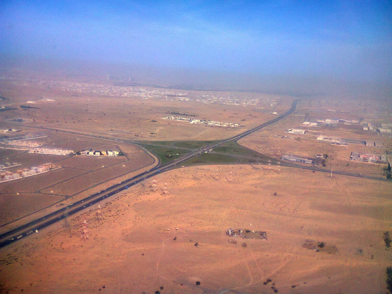 An aerial view of a road crossing the desert outside Dubai, United Arab Emirates