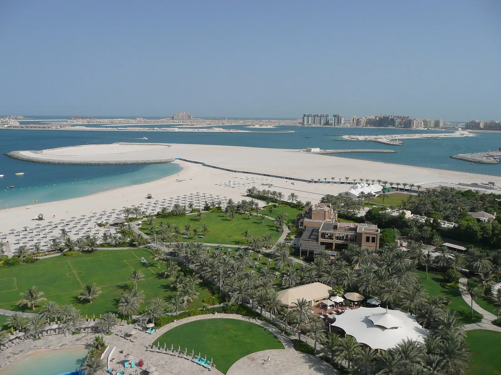 A view over the beach and gardens towards the Palm Jumeirah, Dubai, United Arab Emirates