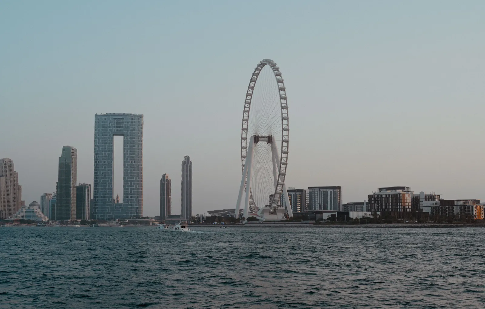 The giant Ain Dubai observation wheel rising above Bluewaters Island with the Dubai Marina skyline behind it