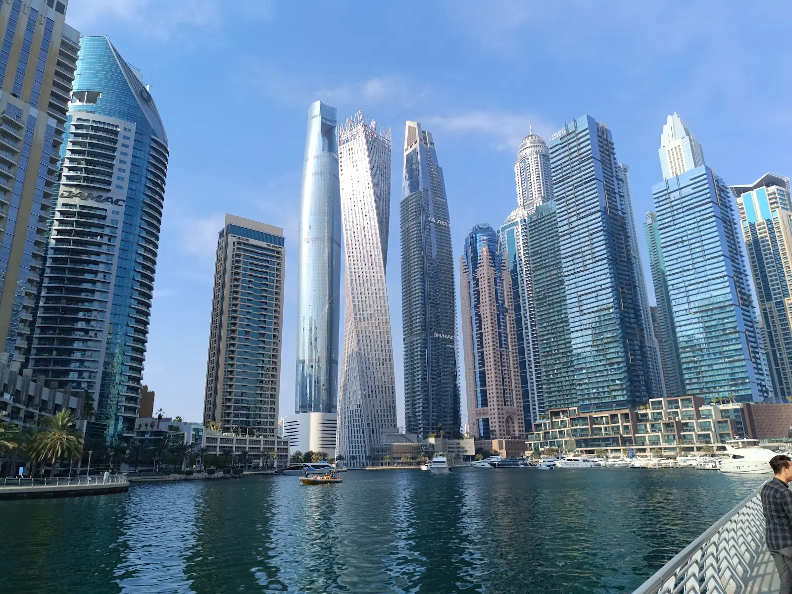 Dubai Marina high rise towers and yachts along the waterfront at dusk in Dubai