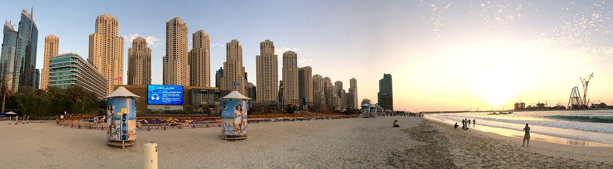 A beach with towers behind in afternoon light