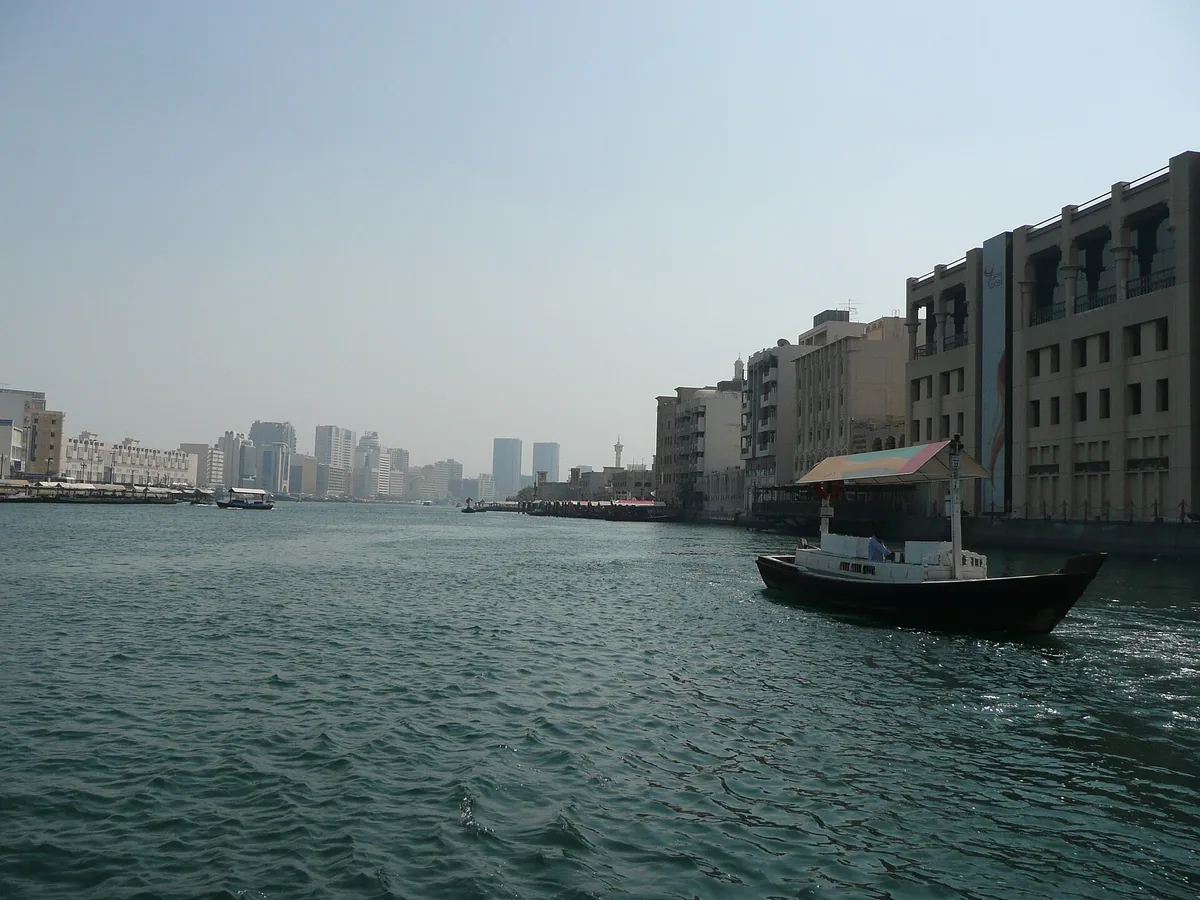 A creek with a ferry boat and low buildings
