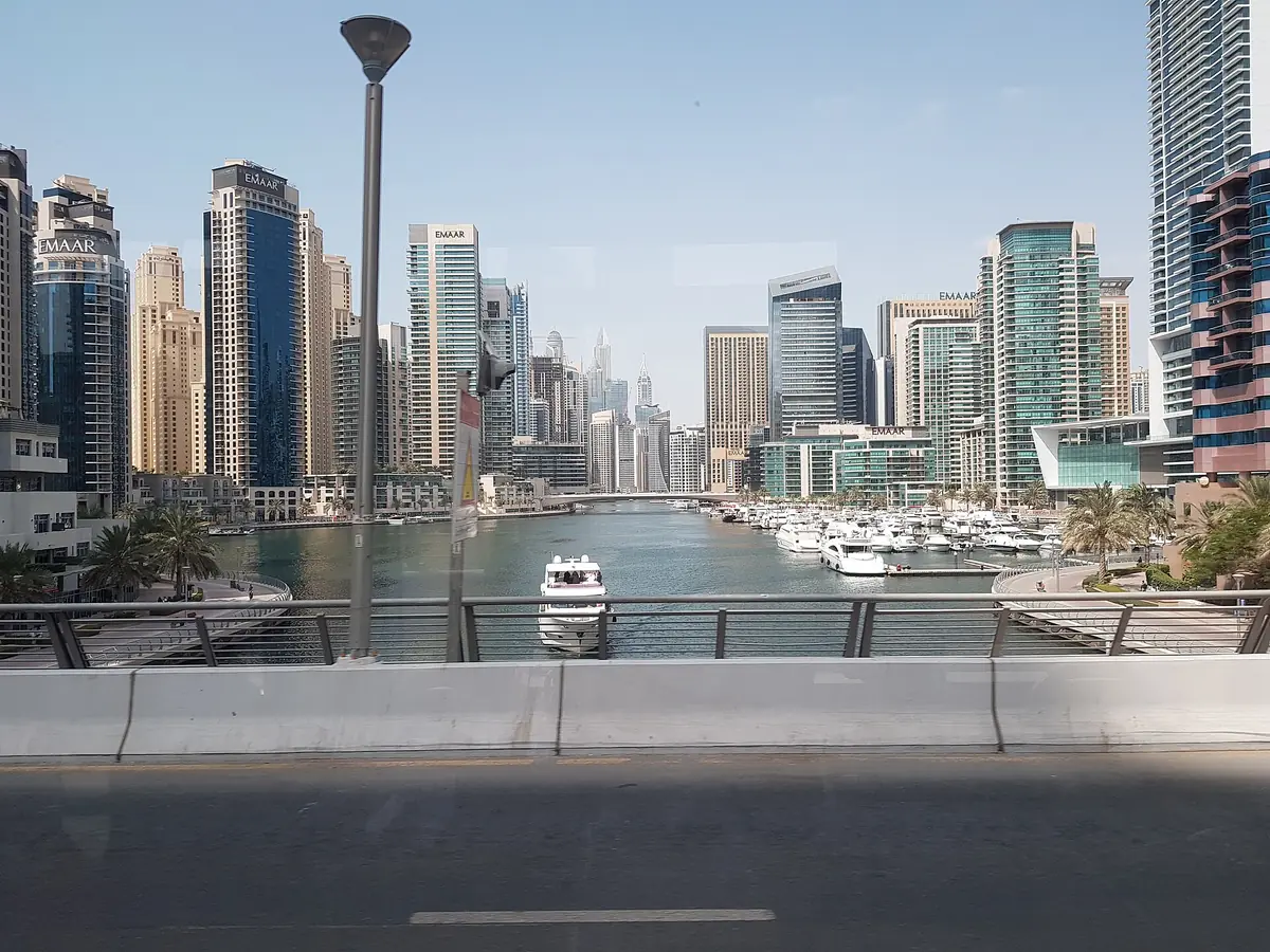 A marina channel with yachts and towers on both sides