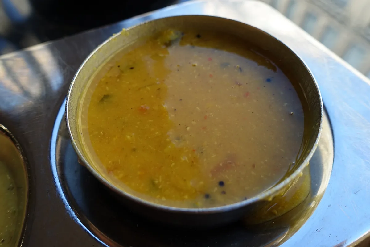 A bowl of south Indian lentil soup on a plate