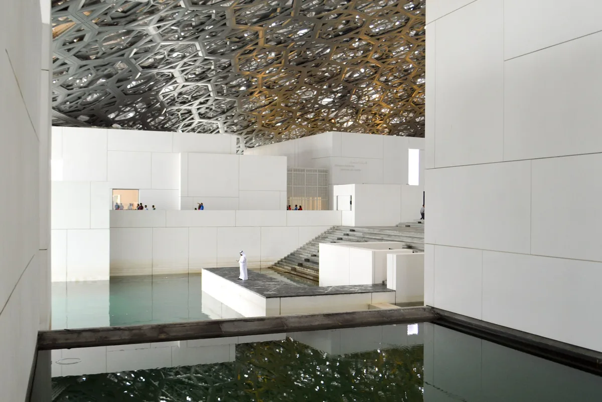 White galleries and a pool of water beneath a perforated dome