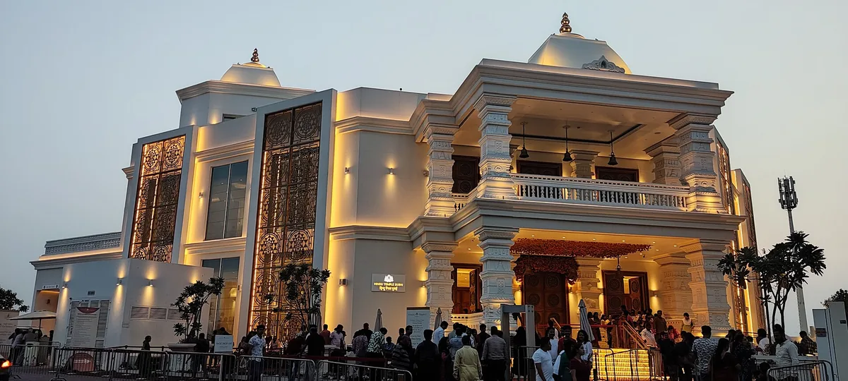 A lit temple facade with a crowd in the evening