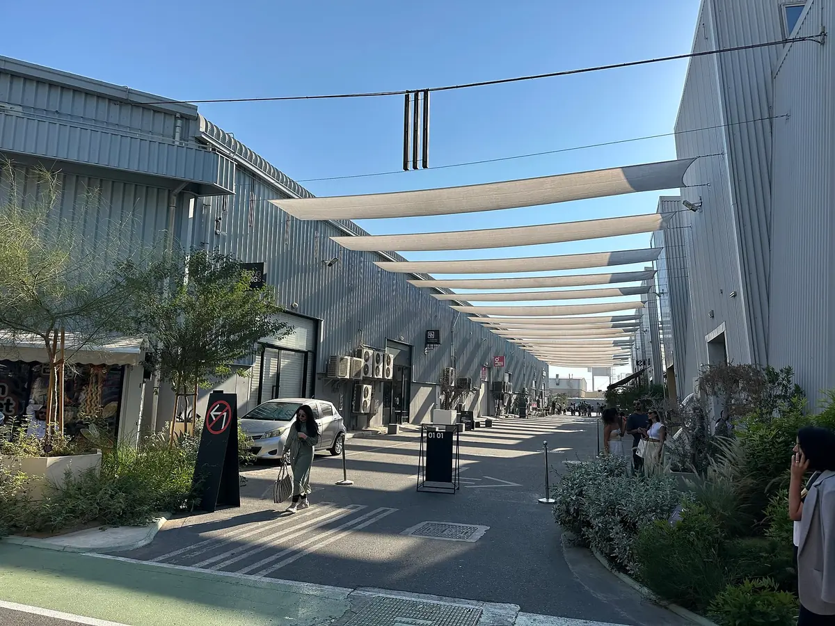 A warehouse lane with a white shade canopy and galleries on both sides