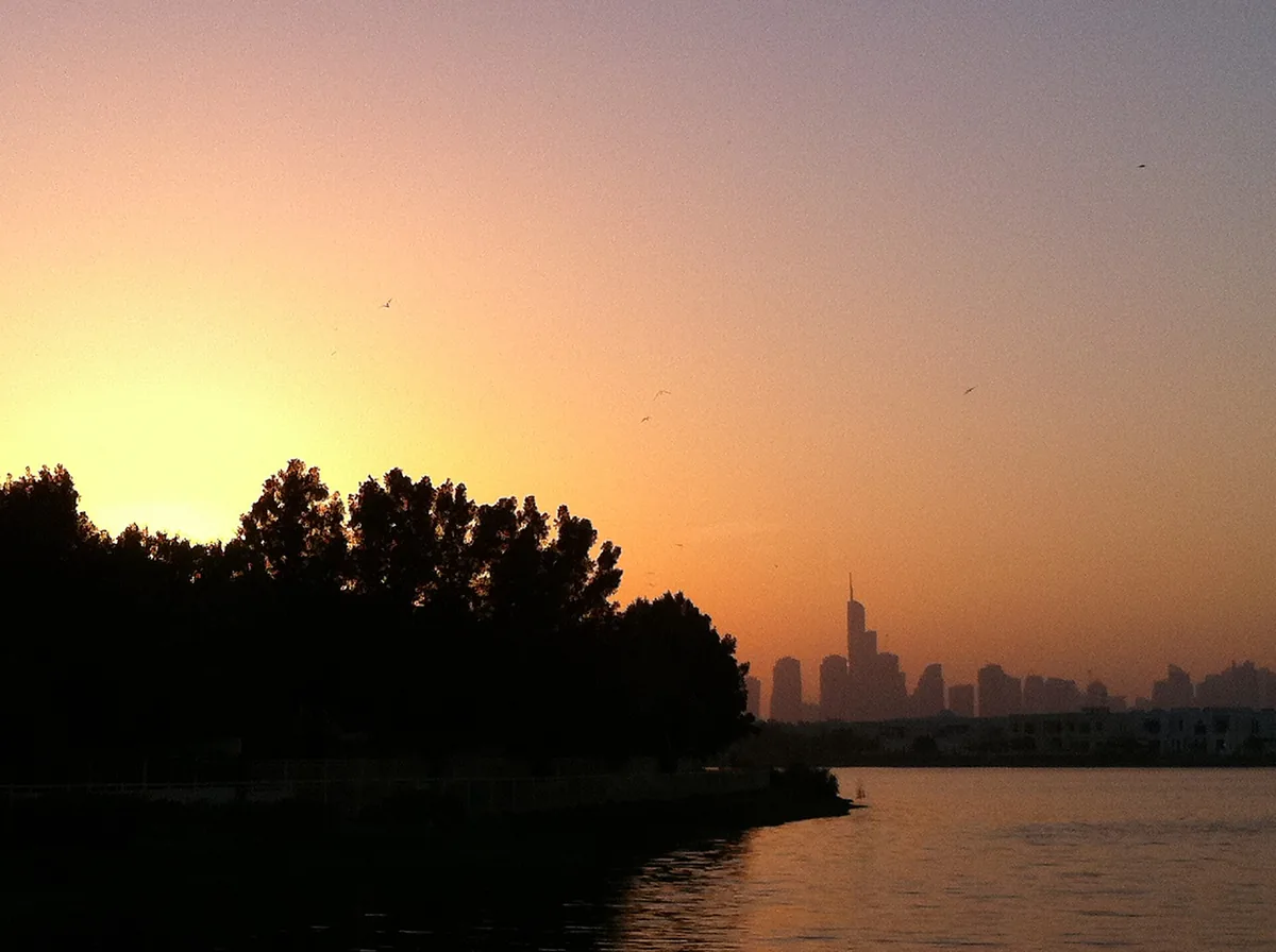 Sunset over a waterway with a distant skyline