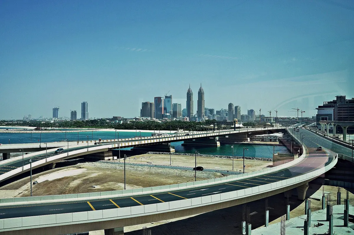 A curved beachfront promenade facing a distant skyline