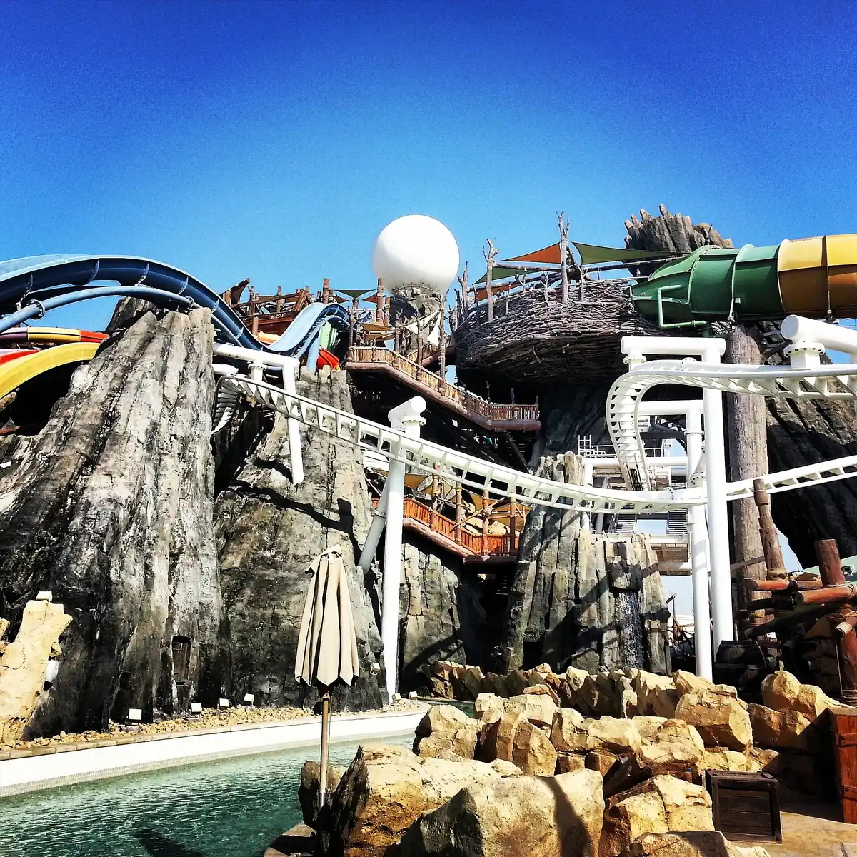 Coloured water slides curling around an artificial rock structure