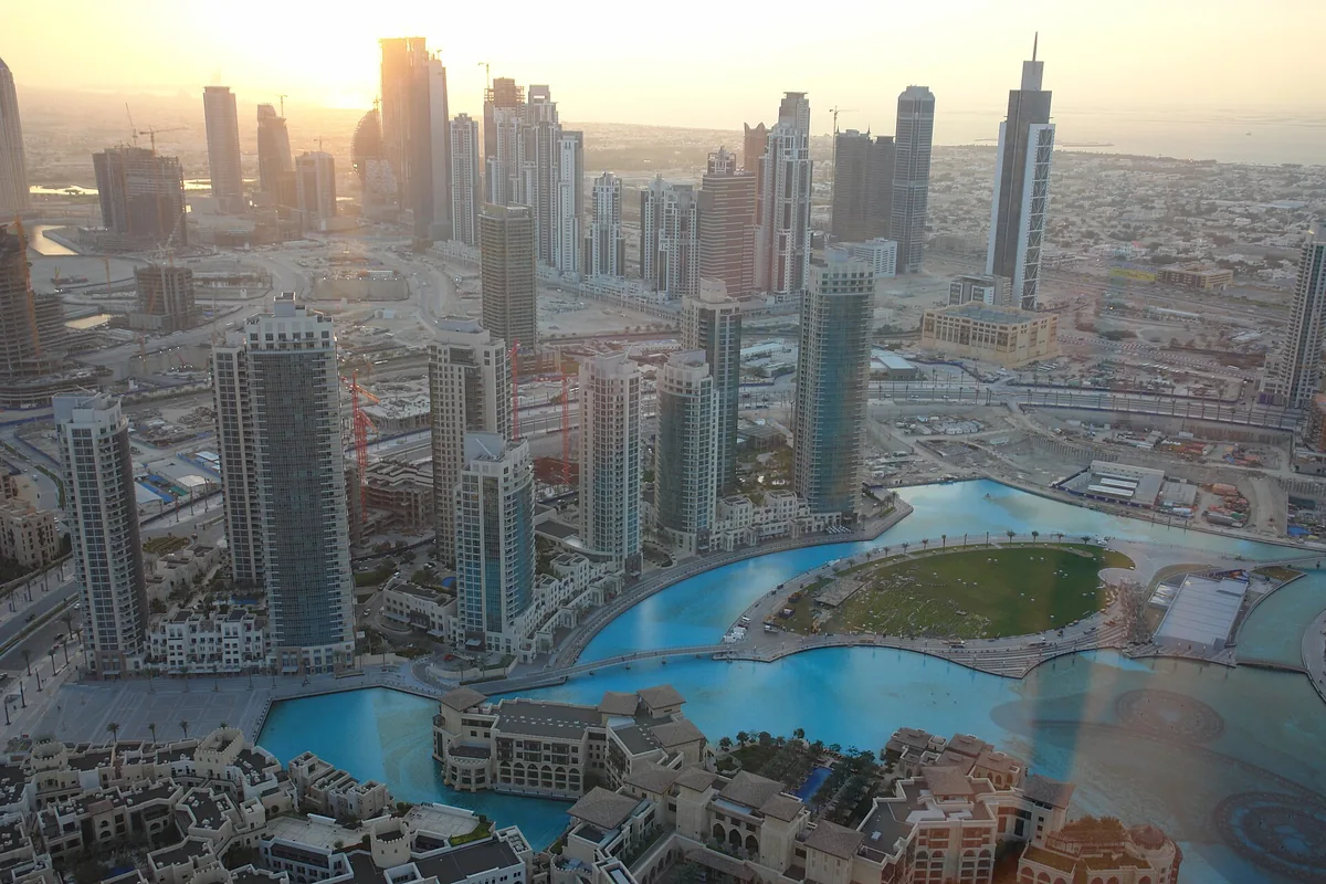 An aerial view of Dubai towers and the water channel in golden light