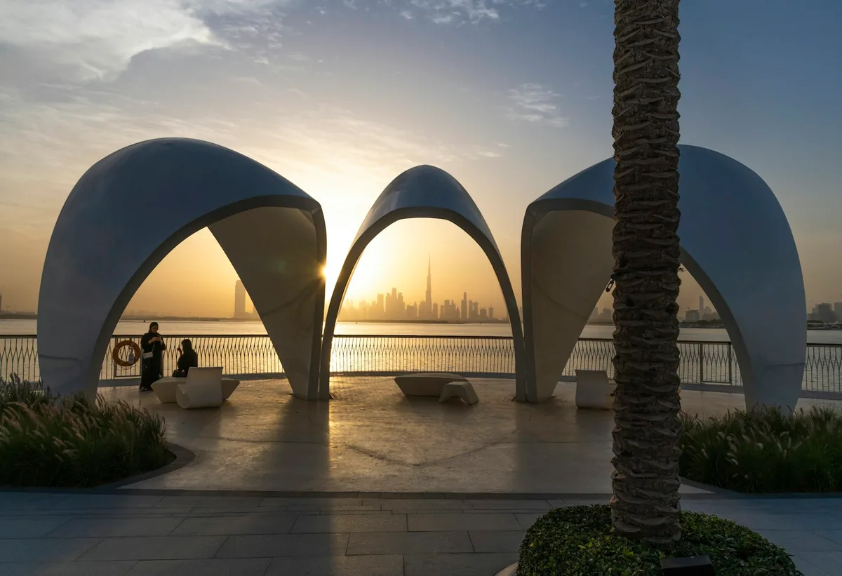 Concrete arches on a promenade facing the skyline at sunset
