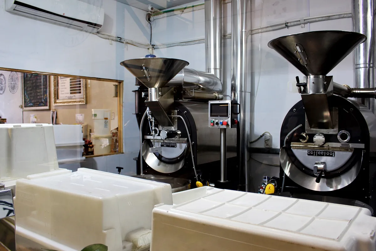Two stainless steel coffee roasters in a roasting room