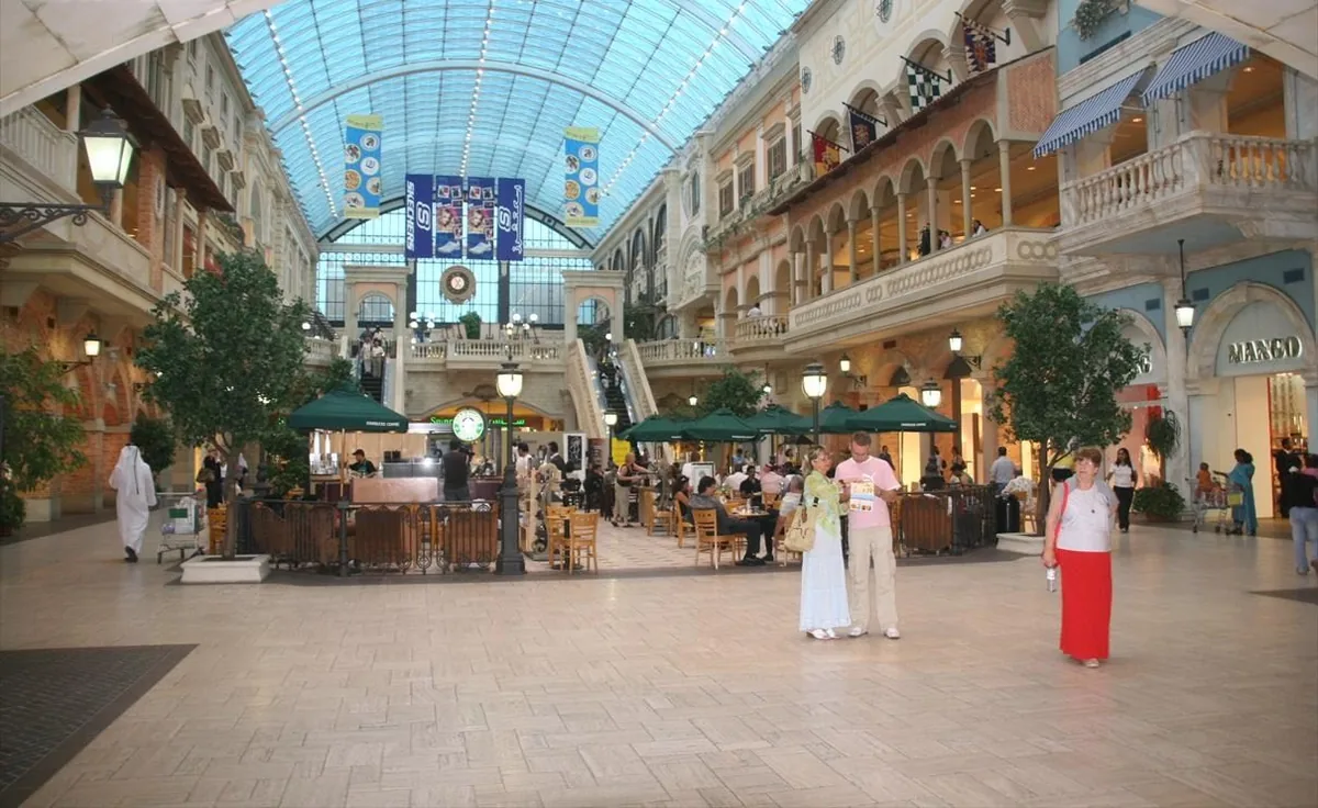 An Italian style mall atrium with a glass roof and ornate balconies