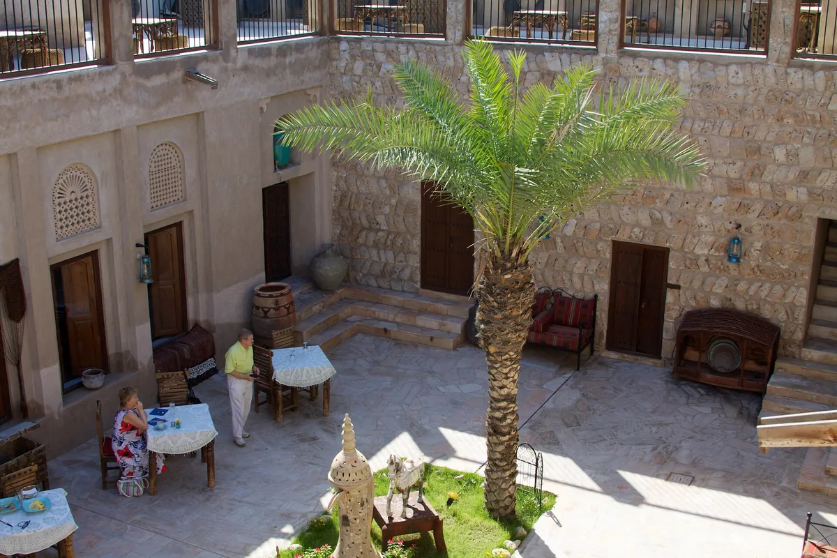 A traditional restaurant courtyard with a palm and stone walls