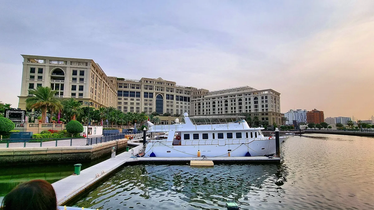 A moored boat before low buildings on the waterfront