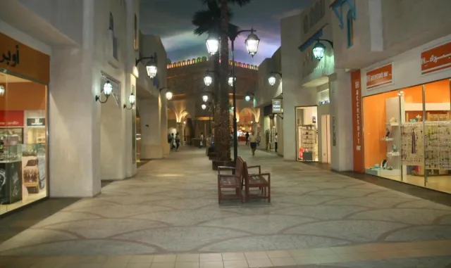 A mall passage styled as an old street with iron lamps and a painted ceiling