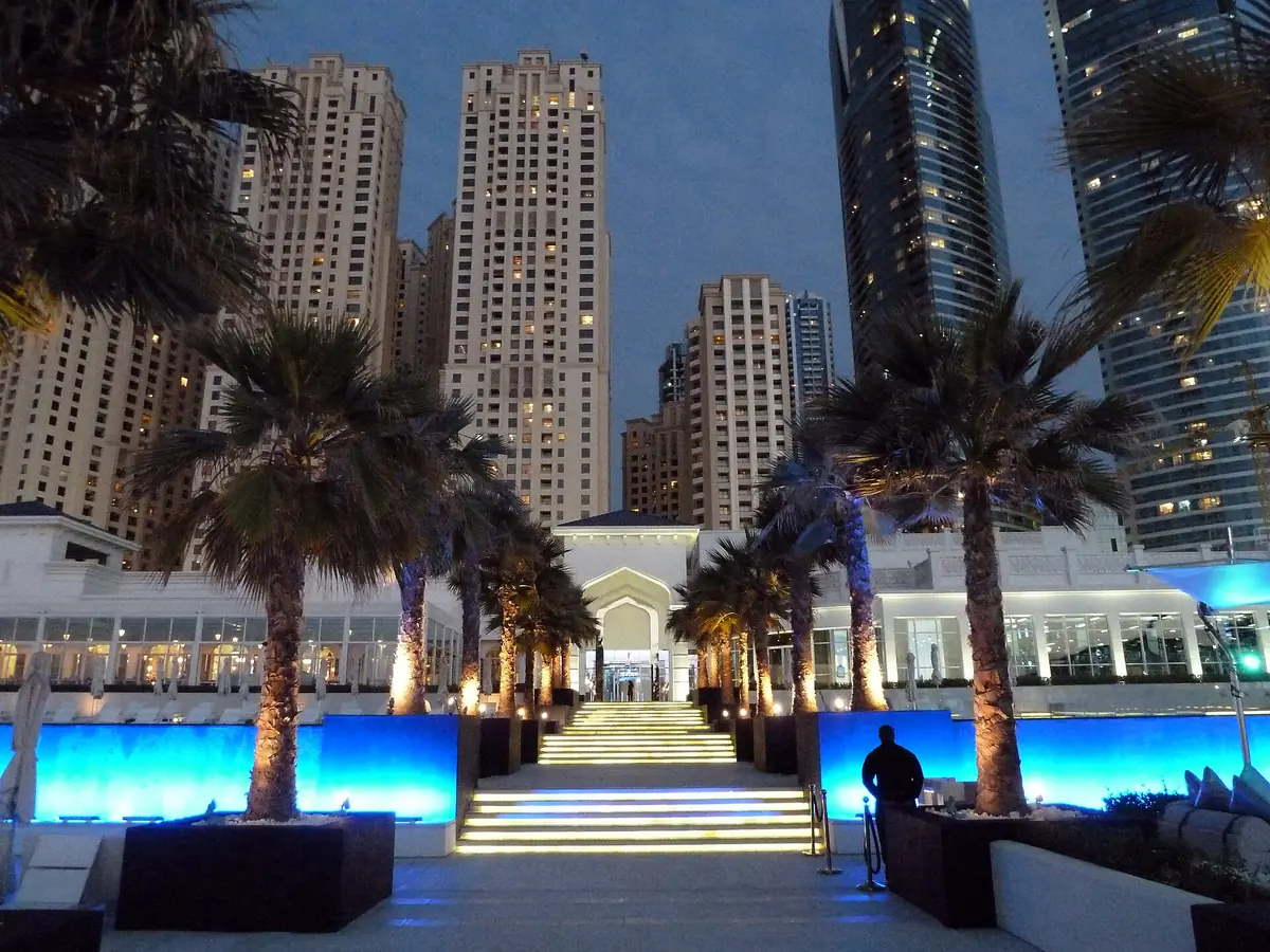 A lit beach club among palms at night
