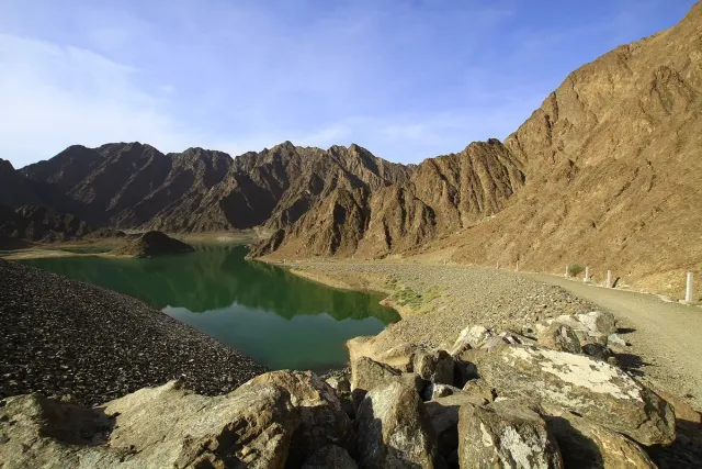 A green water reservoir between bare rocky mountains