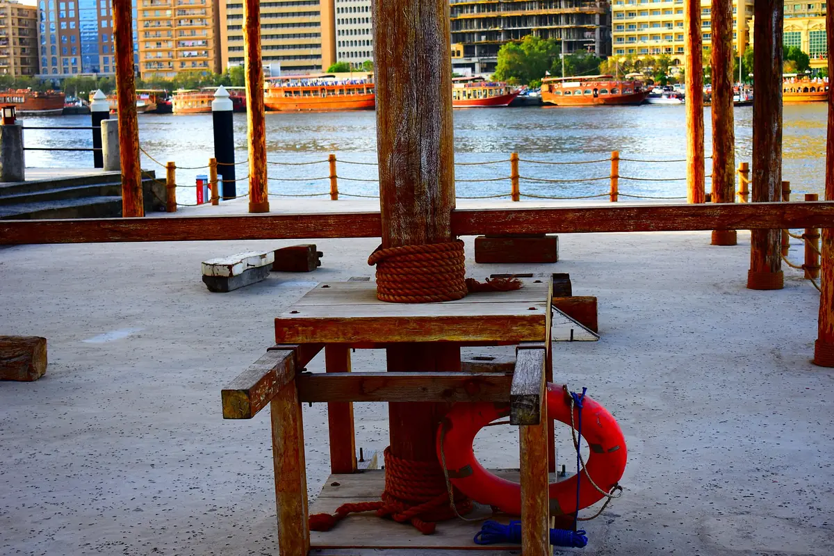 A wooden structure on the harbour edge with life rings