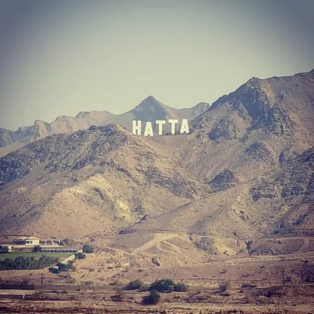 Large white letters on the slope of a bare rocky mountain