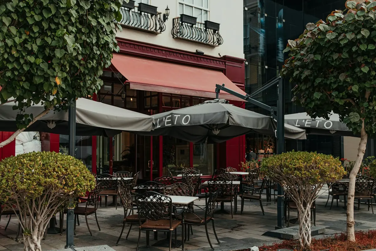 A cafe terrace with parasols and greenery