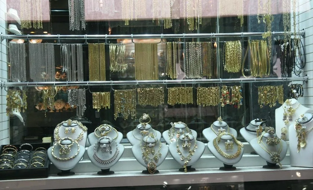 A shop window packed with gold necklaces on display busts